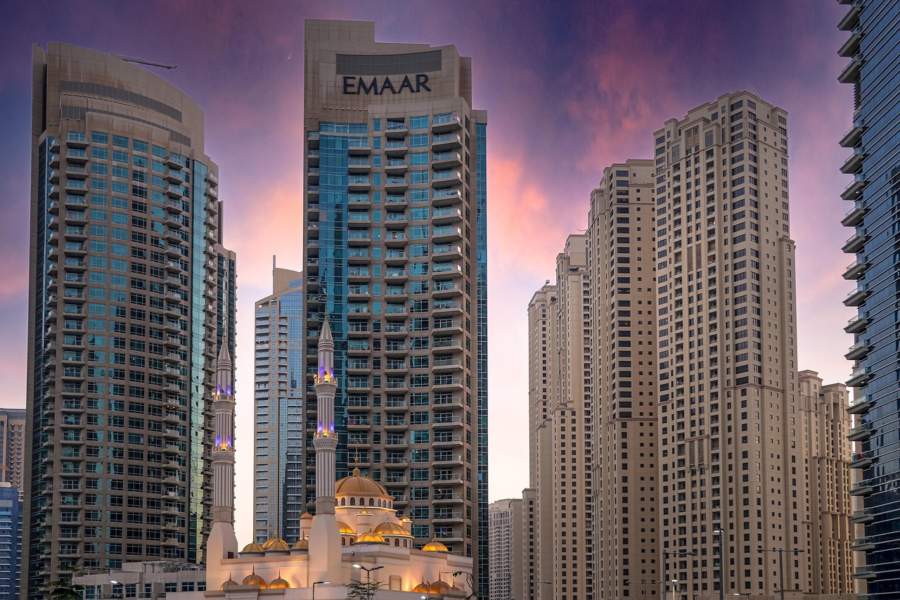 Modern high-rise buildings in Dubai with a mosque in the foreground